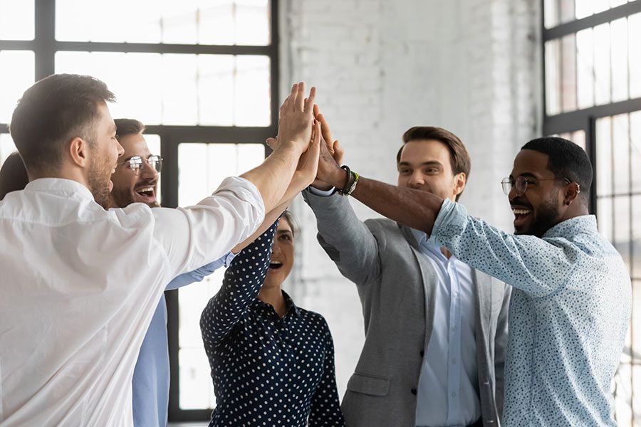 About Our Agency - Diverse Group of Employees Giving Each Other High Fives at the Office