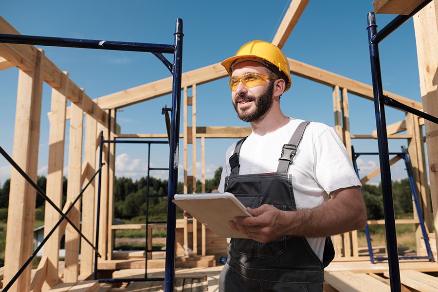 Specialized Business Insurance - View of Contractor Checking Project Notes on New House Construction Jobsite
